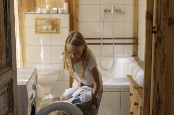 girl with blonde hair doing laundry